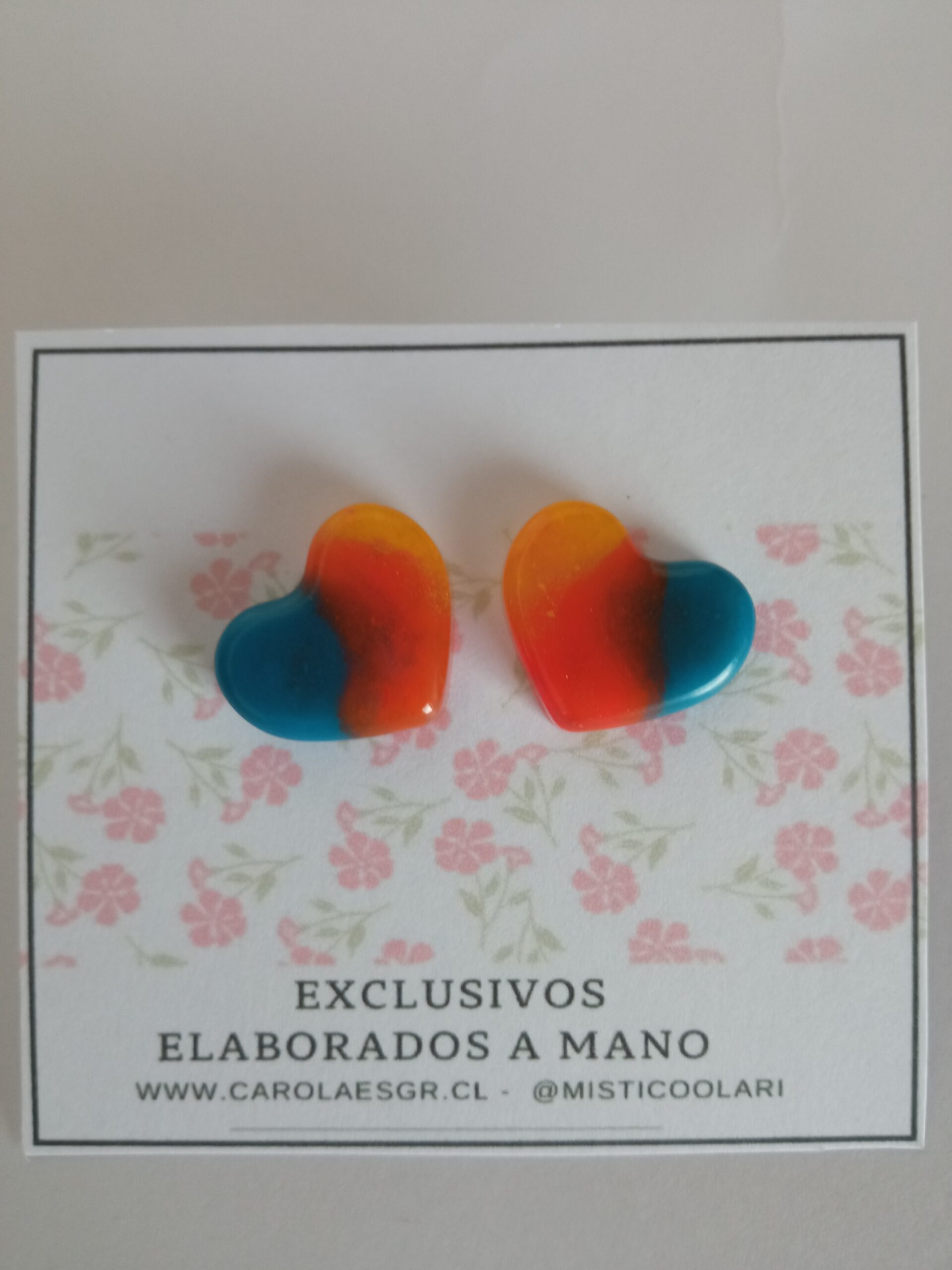 Corazón en colores, aretes encapsulados en colores. Base en acero quirúrgico.